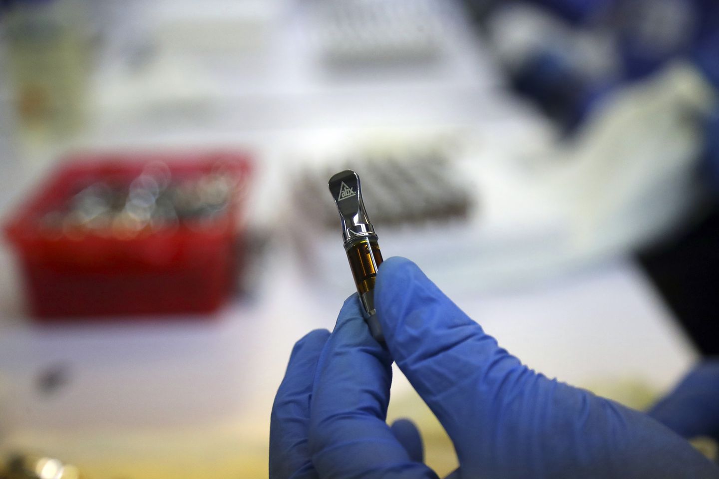 A worker held a filled marijuana vape cartridge at a California cannabis facility in 2018.
