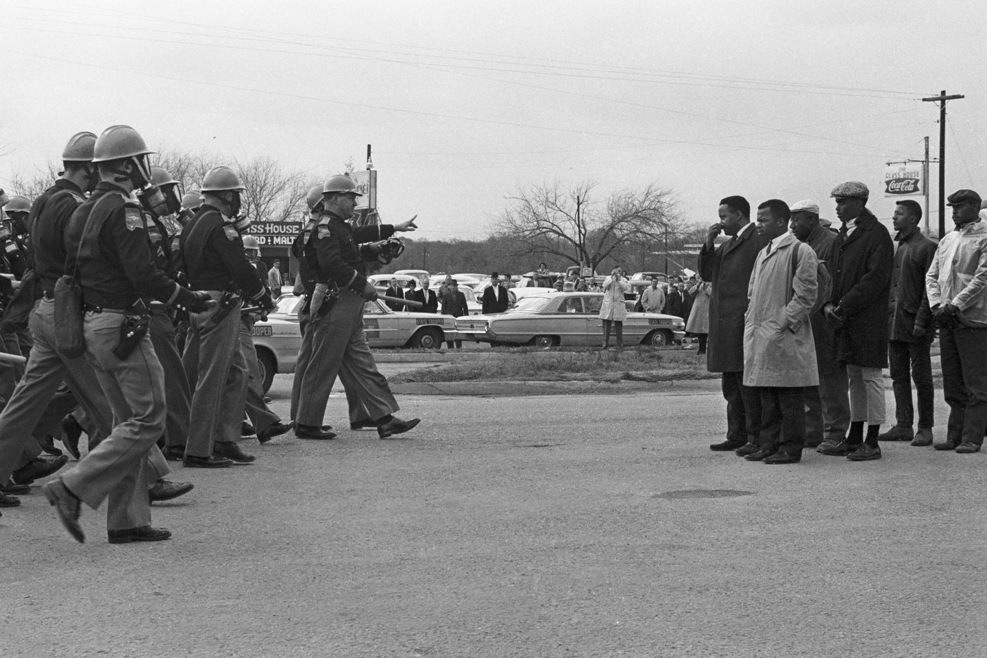 John Lewis, in the light-colored raincoat, with other protesters facing Alabama state troopers on Bloody Sunday, March 7, 1965, in Selma, Ala.