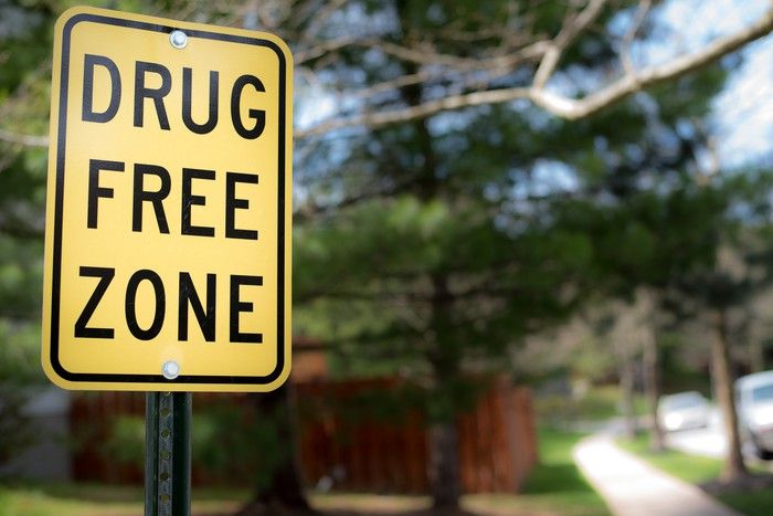 A drug-free zone street sign on an empty street. 