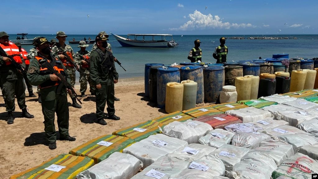 Sacks containing illegal drugs and plastic barrels containing fuel, seized by the armed forces of Venezuela are displayed at a beachside campsite in the village of Tiraya, Venezuela, Sept. 5, 2022. 