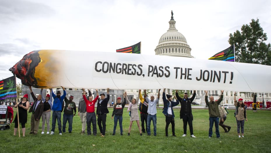 Marijuana activists hold up a 51-foot inflatable joint during a rally at the U.S. Capitol to call on Congress pass cannabis reform legislation on Tuesday, Oct. 8, 2019.