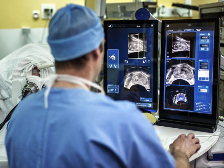 A surgeon sitting in front of screens of a Focal One device performs a robot-assisted prostate tumorectomy using ultrasound imaging on April 10, 2014 at the Edouard Herriot hospital in Lyon, center France. JEFF PACHOUD/AFP via Getty Images