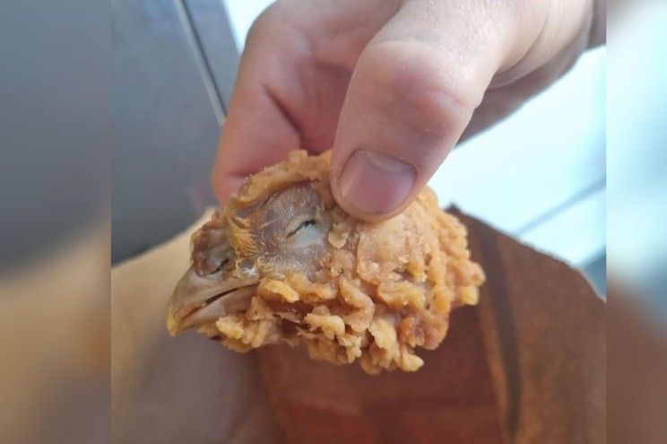 A horrified customer found an entire chicken head in her KFC hot wings meal.