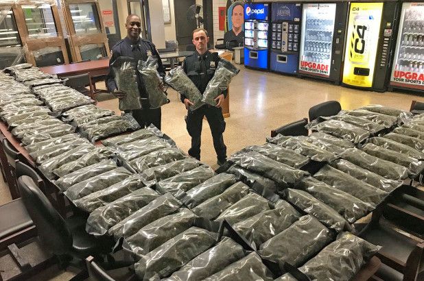 NYPD officers from the 75th Precinct with 106 pounds of confiscated marijuana.