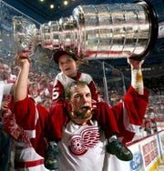 Darren McCarty with his then 5-year-old son, Griffin on his shoulders raises the Stanley Cup during post game celebrations after their Game 5 win over the Carolina Hurricanes in 2002.