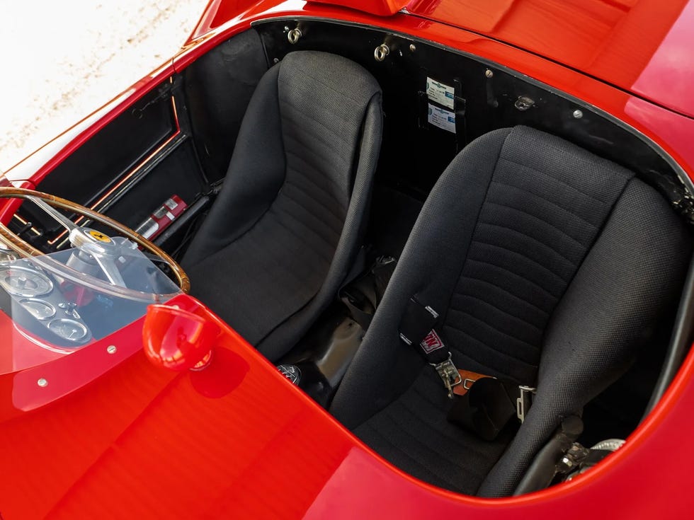 Two seats, a seatbelt and a fire extinguisher on the passenger side are seen inside the 1955 Ferrari 410 Sport Spider.